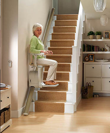 woman riding on a Stair chair lift in Delaware, OH, Lancaster, OH, Kokomo, IN, Lexington, and Surrounding Areas