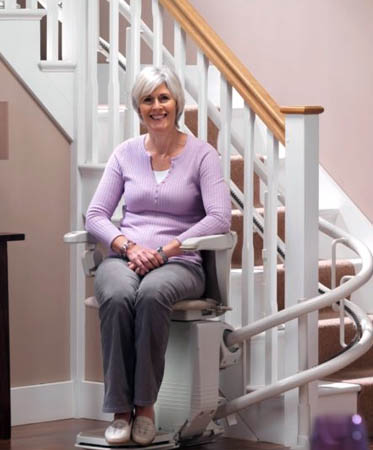 woman riding on a stairlift rental in Muncie, IN, Louisville, Columbus, OH, Dayton, Indianapolis, and Surrounding Areas